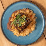Mole braised short rib served over risotto on a blue plate