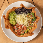 Vegetarian Tostada Verde Crunch tortilla bowl with guacamole, black beans, cheese and salsa