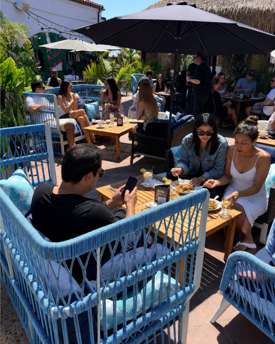 Guests enjoying happy hour on the open-air patio at Casa de Onda in Costa Mesa
