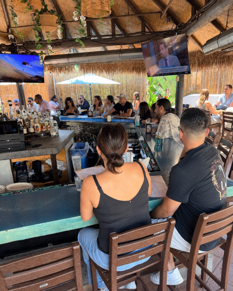 Guests at the thatched-roof outdoor bar during happy hour at Casa de Onda in Costa Mesa