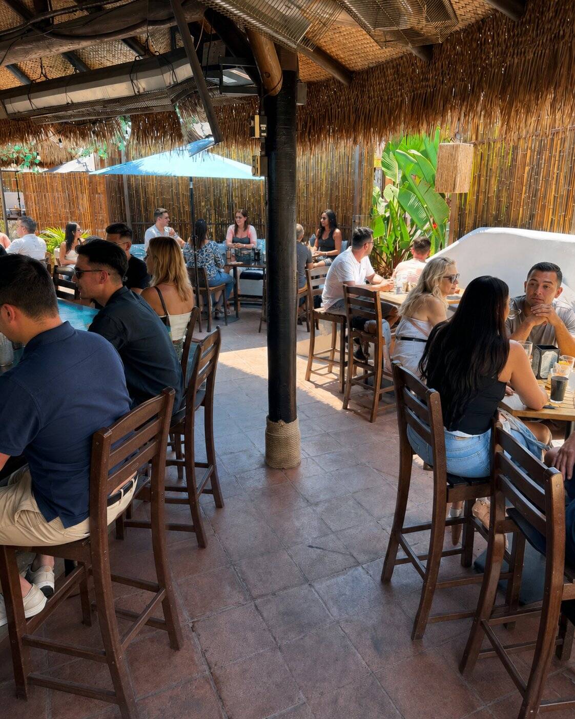 Weekend brunch guests under the palapa at Casa de Onda, Costa Mesa